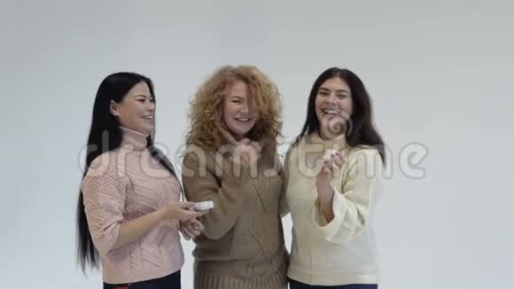 三个女朋友白色背景的女性手里拿着化妆品的女人慢动作视频的预览图