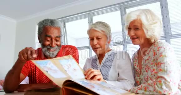 积极的高加索老人在养老院观看相册的正面看法视频的预览图