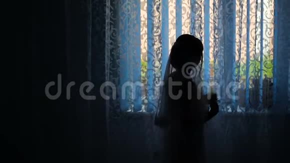 酒店窗户附近一位新娘的剪影视频的预览图