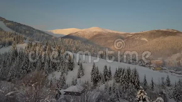 飞越喀尔巴阡山的一个村庄鸟山上白雪覆盖的房子的视野乡村景观视频的预览图