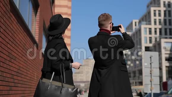 时尚的情侣游客在城市里拍一张欧洲景点的照片视频的预览图