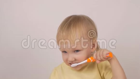 小白种人女孩在白色背景下清洁牙齿慢动作牙刷视频的预览图