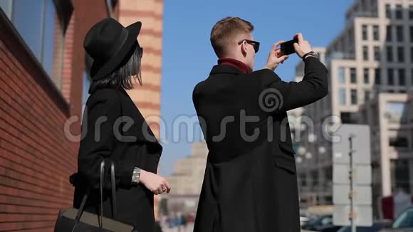 时尚的情侣游客在城市里拍一张欧洲景点的照片视频的预览图