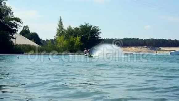 Wakeboarder骑着相机在他的Wakeboard慢动作上撞上水视频的预览图