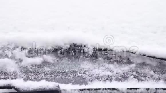 挡风玻璃雨刷缓慢地从汽车挡风玻璃刷雪视频的预览图