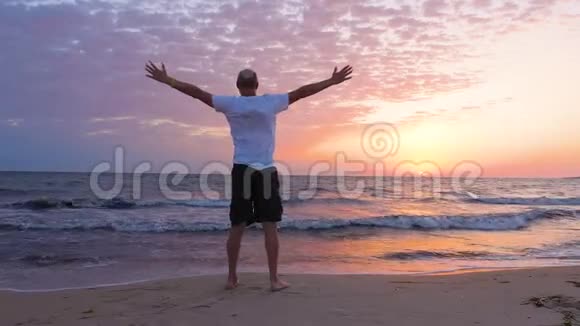 欢乐的人站起来双手在海边享受早晨的日落视频的预览图