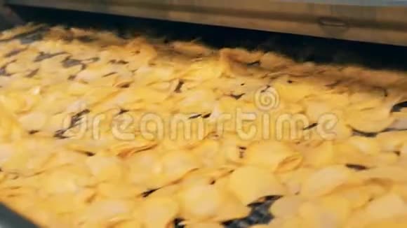 土豆薯片在油煎后在工厂生产线上移动视频的预览图