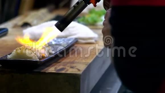 切夫的慢动作燃烧一条鱼用吹嘴使寿司焦糖化视频的预览图