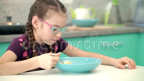 在厨房吃玉米片的女孩儿童食用健康食物肖像视频的预览图