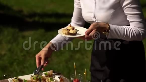 穿制服的女服务员把开胃菜摆在盘子里视频的预览图