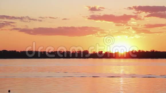 平静的河水的壮观景色美丽的橙色日落的海岸线视频的预览图
