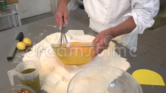 一位糕点师在面粉和糖中加入混合鸡蛋视频的预览图