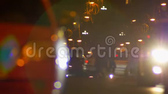 模糊的镜头缓慢行走的行人和快速移动的汽车在傍晚五彩的城市灯光背景视频的预览图