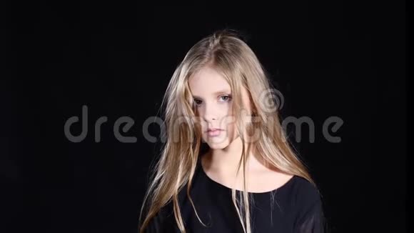 模特女孩在黑色背景上摆姿势金发少年看着镜头露出脸上的情绪4k视频的预览图