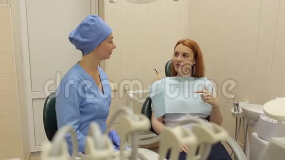 一个医生牙医和一个女病人的肖像他们竖起大拇指视频的预览图