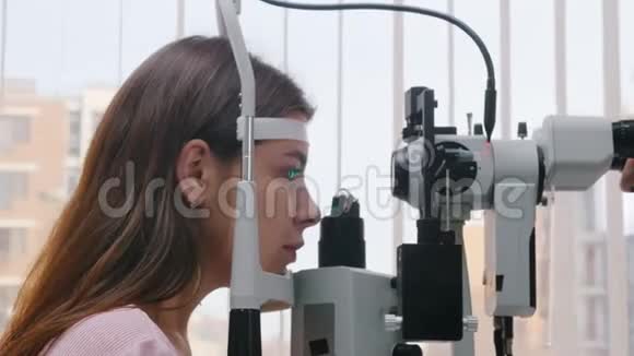 眼科治疗一名年轻女性检查她的视力瞳孔对光的反应视频的预览图