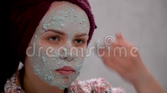 女人把绿色化妆面具戴在脸上在浴室里照镜子视频的预览图