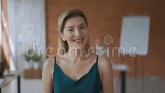 女孩肖像中镜头友好的女人微笑着看着镜头现代化办公室4K视频的预览图