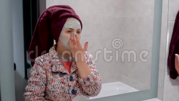 女人把绿色化妆面具戴在脸上在浴室里照镜子视频的预览图