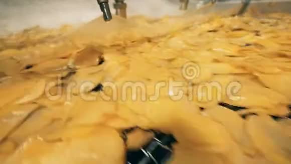 炸土豆薯片在一条线上移动覆盖着油视频的预览图