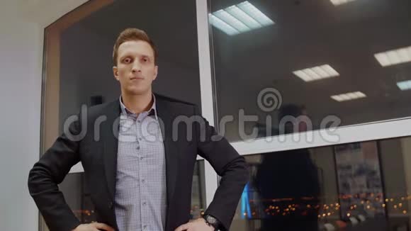 成功的商人穿着古典正式西装双手交叉在靠窗的胸前站在晚间办公室视频的预览图