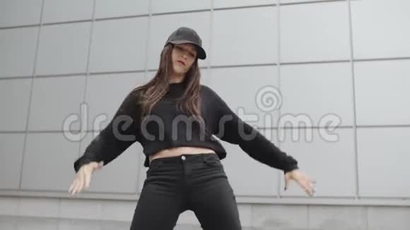 穿黑色衣服的女人跳舞现代嘻哈舞摆姿势在城市环境中跳舞视频的预览图