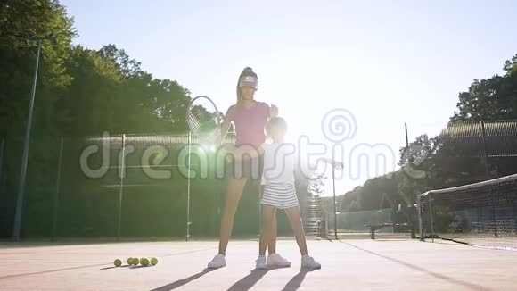 漂亮的女教练教小女孩打网球视频的预览图