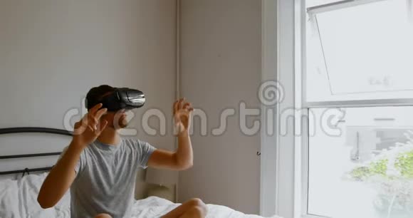 在卧室4k的床上使用虚拟现实耳机的男子视频的预览图