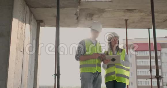 一名女工程师和一名男工程师用平板电脑和手机对建筑进行可视化视频的预览图