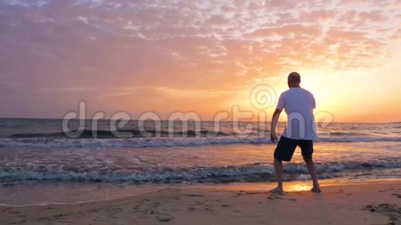 男子训练太极拳清晨日出海边天视频的预览图