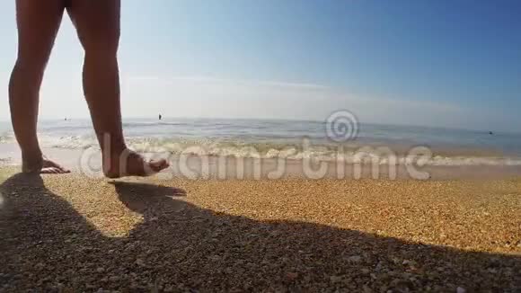 女人腿在沙滩上海浪冲走了脚印视频的预览图