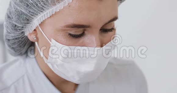 特写镜头中的女医生在面具谁做注射程序医生肖像视频的预览图