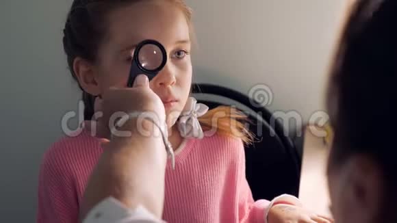 验光概念医生用放大镜检查小女孩视频的预览图