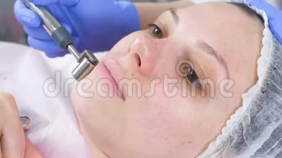美容师为一个年轻女人做了一个微电流手术面部特写侧视视频的预览图