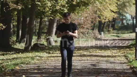 一个拿着手机走路的少年慢动作视频的预览图