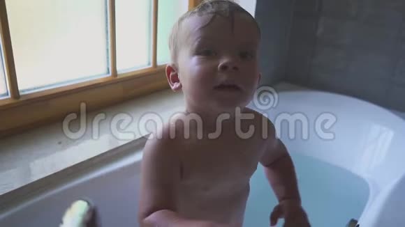 快乐的微笑男孩在浴室里游泳和玩耍视频的预览图