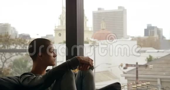 男人坐在靠近窗户的沙发上视频的预览图