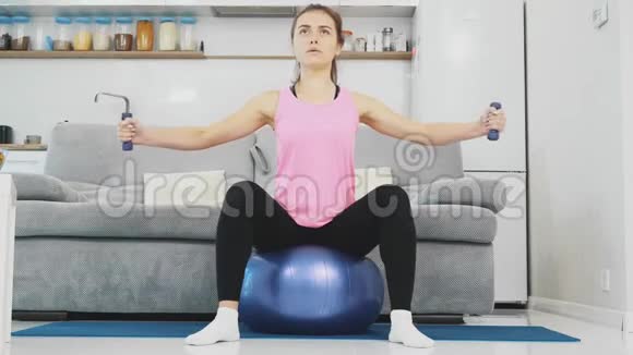 那个女孩坐在球上做各种体育锻炼视频的预览图