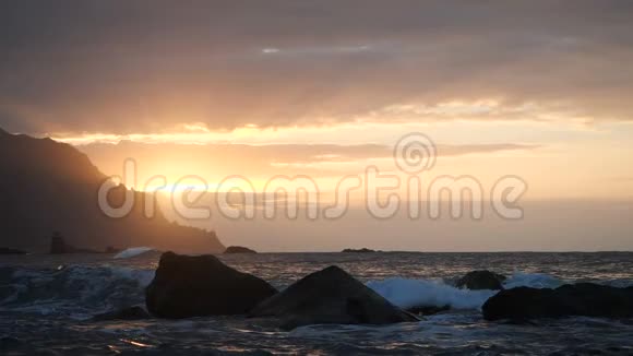 在加那利群岛的特内里费美丽的日落光线下海浪在空中升起一股巨浪冲过来视频的预览图