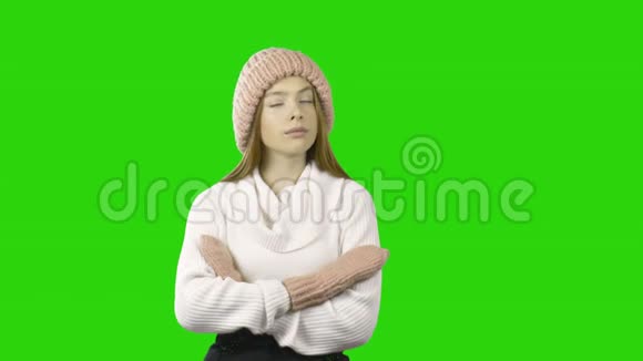 可爱的年轻红发女人戴着针织帽子和手套交叉双臂想着表达着她的情感视频的预览图
