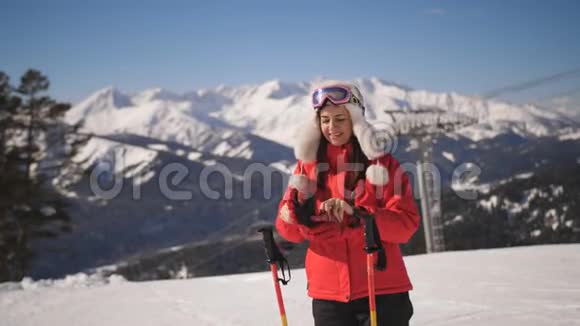 山地滑雪场女滑雪者特写肖像穿着滑雪服和滑雪护目镜看着摄像机和视频的预览图