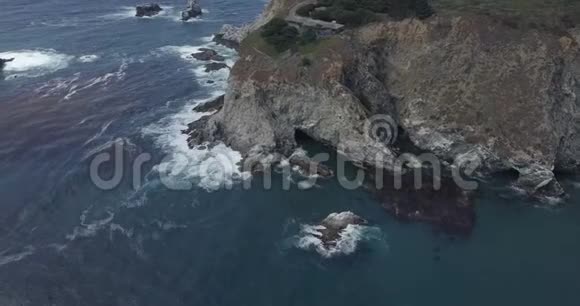 美丽的顶景无人机拍摄惊人的深蓝色海浪泡沫岩石悬崖海岸线在大苏尔加州视频的预览图