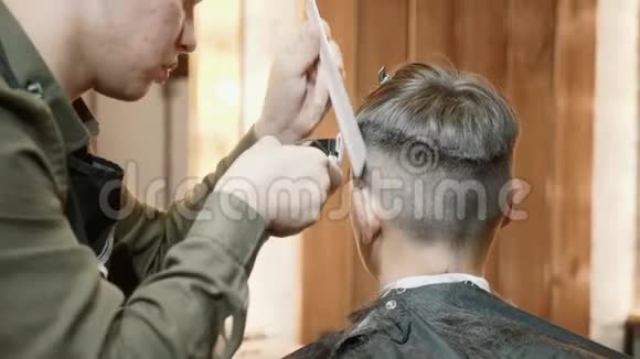 男士美容师理发店剪发在年轻人的头上剪发器视频的预览图