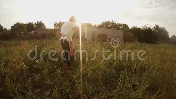 一位穿着传统的乌克兰民俗服装的年轻女子在花园里发现了一个西瓜并把它拿给照相机看视频的预览图