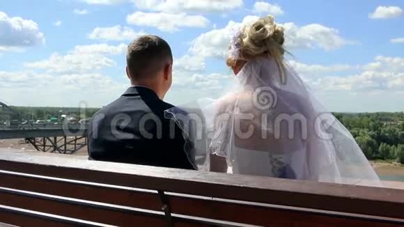 新娘和新郎坐在后景中视频的预览图