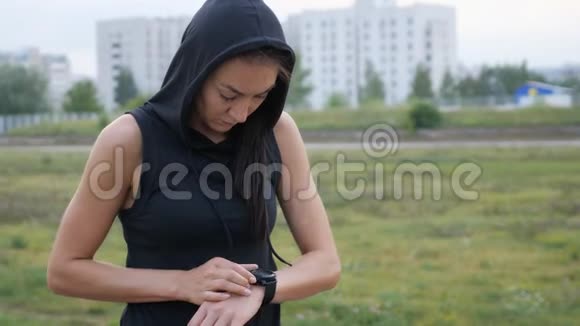 女人为跑步设置健身智能手表女运动员检查手表视频的预览图