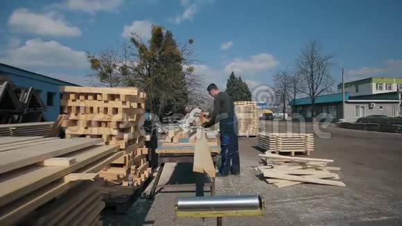 工业青年木工操作木材切割机男人切木木板视频的预览图