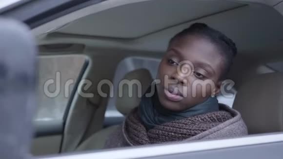 自信的非裔美国妇女坐在车里的肖像特写漂亮的女人开车女孩视频的预览图