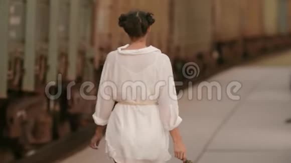 在火车站的火车轨道附近行走的女人美自由夏日旅行理念视频的预览图