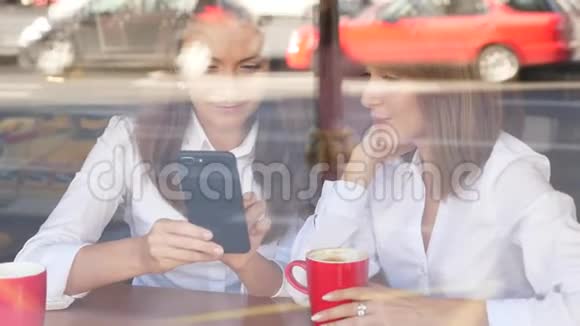 两个女孩在智能手机上聊天和寻找视频的预览图